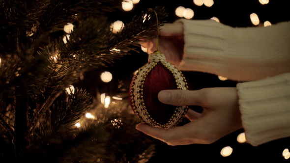 Hangs Christmas Ball With Tree