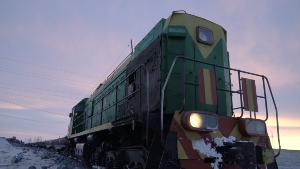 Handheld Tracking Shot of Old Diesel Locomotive at the Unloading Station for Copper Ore in Winter.