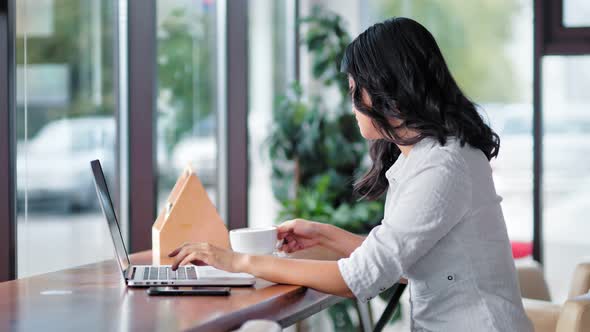 Asian Young Woman Drinking Coffee Using Laptop Having Relaxing Time alt