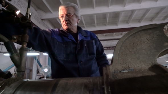 Senior Mechanic in Overalls in Heavy Machine Workshop. Hard Surfacing By Submerge Arc Welding