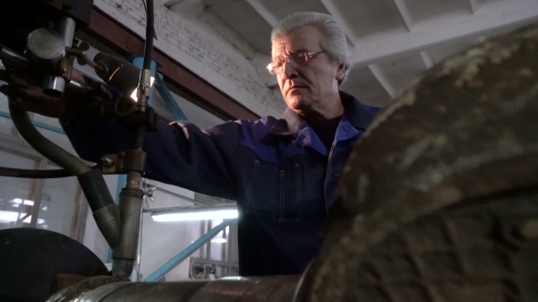 Senior Mechanic in Overalls in Heavy Machine Workshop. Hard Surfacing By Submerge Arc Welding