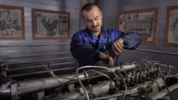 The Mechanic Adjusts the Valve on the Diesel Engine. In Hands Tools.