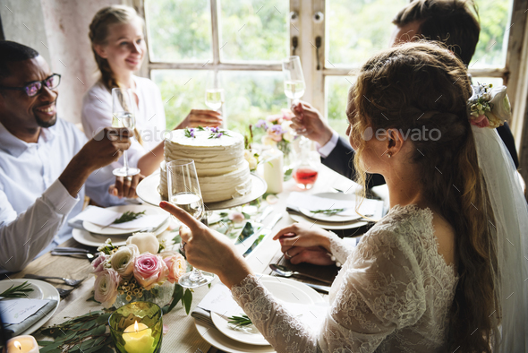 People Cling Wine Glasses On Wedding Reception With Bride And Gr