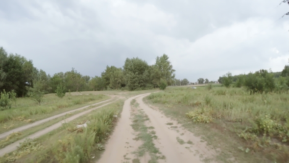 Car Driving Along a Rural Dirt Road