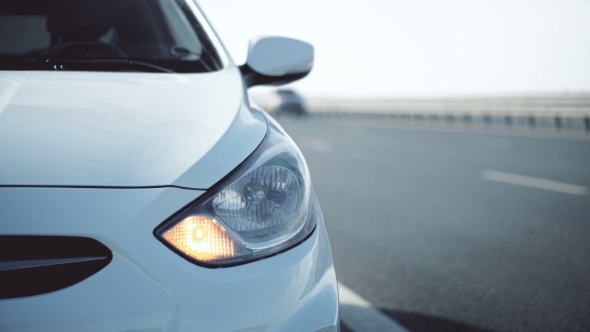 The Car Stands on the Roadside and Blinks with Emergency Lights alt