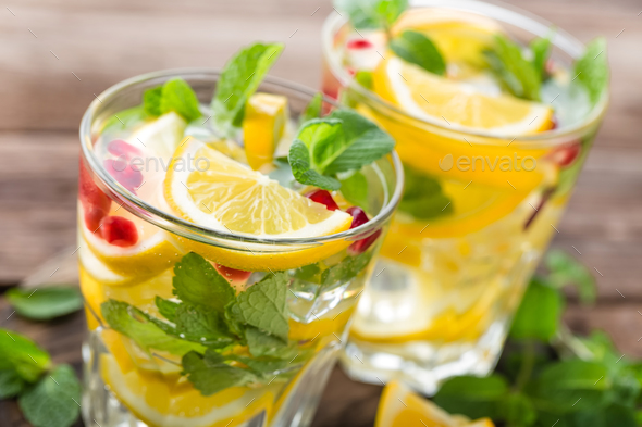 Lemon mojito cocktail with mint and pomegranate, cold refreshing drink or beverage - Stock Photo - Images