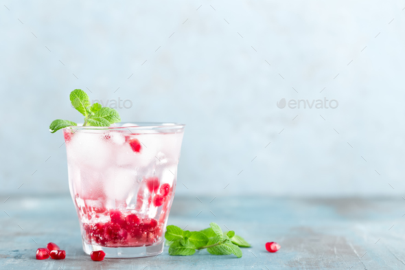 Infused water made of fresh pomegranate and mineral water with ice, cold refreshing and detox drink - Stock Photo - Images