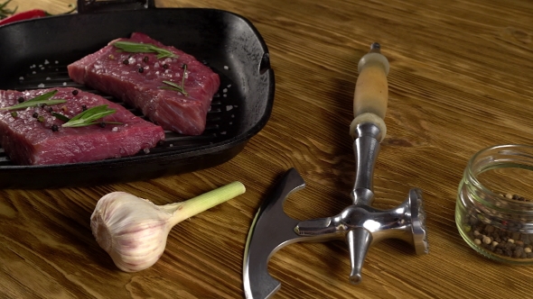 Beef Fillet on a Pan with Pepper, Rosemary, Axe and Garlic.