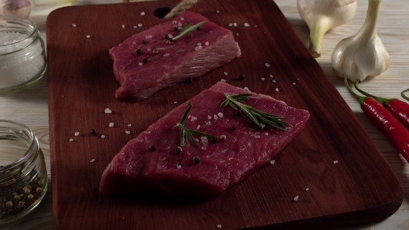 Beef Fillet on a Desk with Pepper, Rosemary and Garlic.