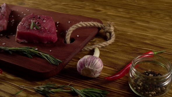 Beef Fillet on a Desk with Pepper, Rosemary and Garlic.