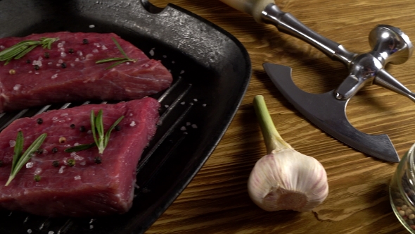 Beef Fillet on a Pan with Pepper, Rosemary, Axe and Garlic.