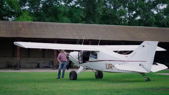 Aviator Inspecting Small Airplane Landed on Airdrome alt