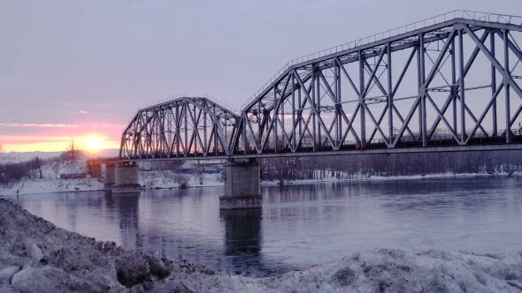 of Railway Bridge Over the River at Dawn with a Mountain Forest and Traffic Highway in the