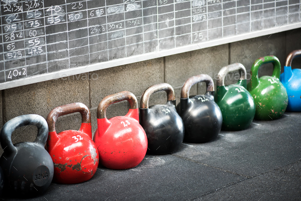 Row of colorful kettlebell weights in a gym - Stock Photo - Images