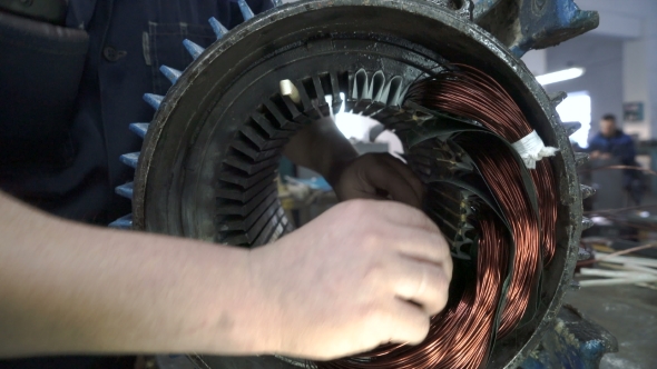 Mechanic Stacks Coils of the Stator. Electric Motor Repairing.