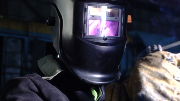 Welder in the Protactive Mask Welding the Metal Parts of the Broken Railway Car