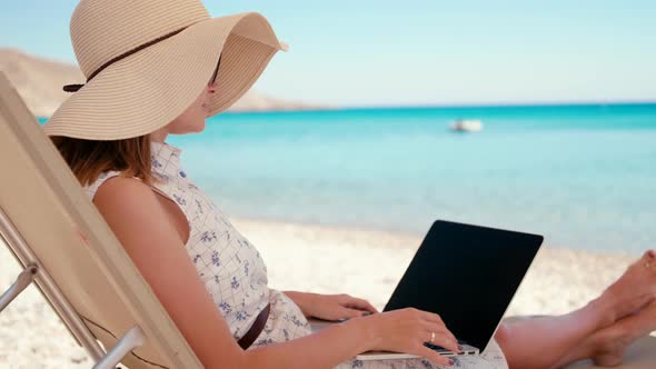Woman Talks Online By Video Call Using Laptop on Sea Beach in Tropical Country