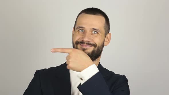 Young Successful Businessman Shows His Forefinger To the Side alt