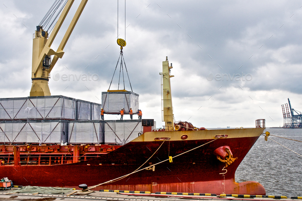 Loading cargo into the ship in harbor - Stock Photo - Images