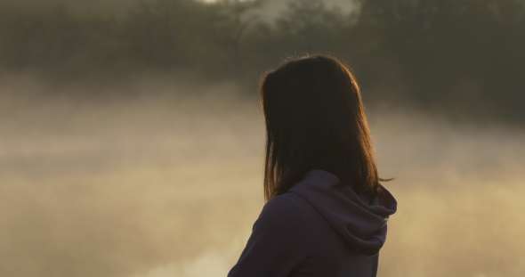 Silhouette of a Woman on a Background of Fog