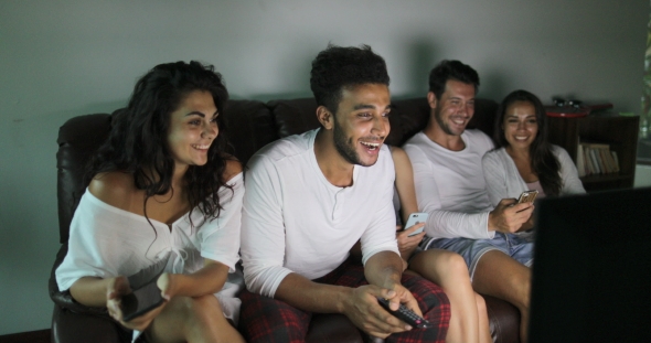 People Group Sitting On Couch Watching Sport Game TV Program Cheering For Team Win, Young Cheerful