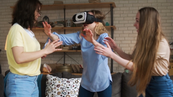 Three Young Female Friends Have Fun Together Using VR Device Actively