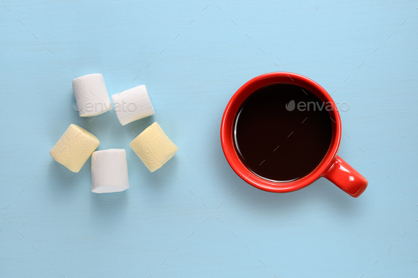Marshmallow and coffee cup on blue table top view