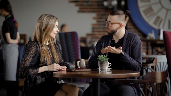 Recently Met Couple Holds a Meeting in the Restaurant for a Cup of Coffee, a Pretty Woman Flirts