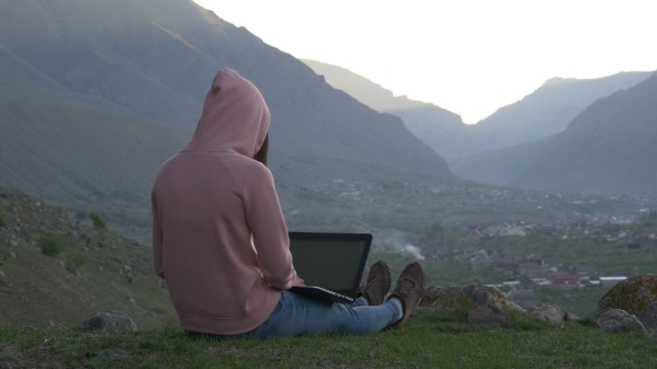 Woman with Laptop in a Mountain Village