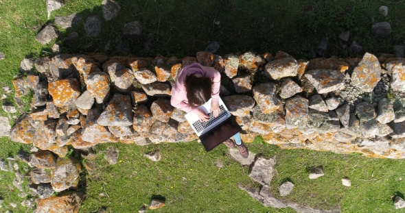 Top View of a Woman with a Laptop on the Rocks