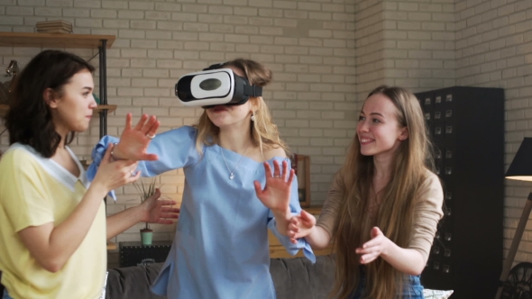 Three Young Female Friends Have Fun Together Using VR Device Actively