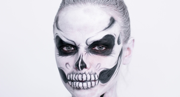 Girl with Creative Halloween Face Art on White Background.