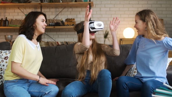 Three Young Energetic Girlfriends Laugh and Move Funny Using Together VR Device