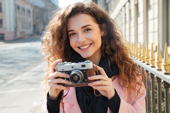 Picture of young woman holding retro camera - Stock Photo - Images