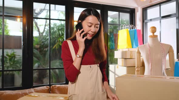 Young Asian woman receive phone call via mobile phone from customer