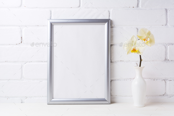 Silver frame mockup with soft yellow orchid in vase - Stock Photo - Images