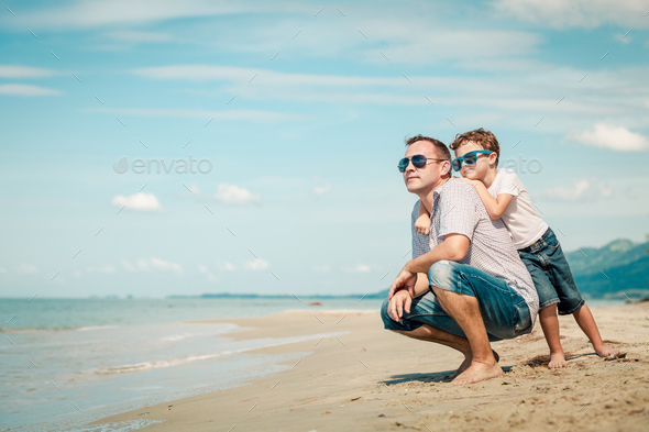 Father and son playing on the beach at the day time. - Stock Photo - Images