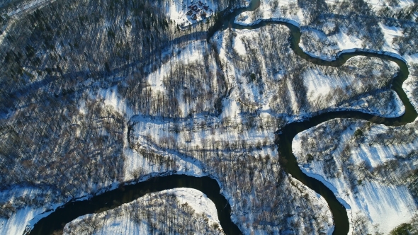 Meandering River Flows Through Plain Among Woodland