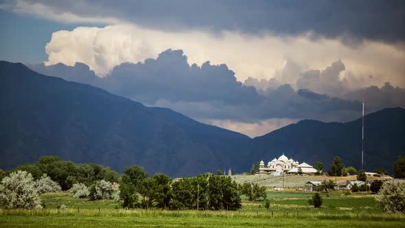 Time lapse zoomed through valley past temple to mountains and clouds alt