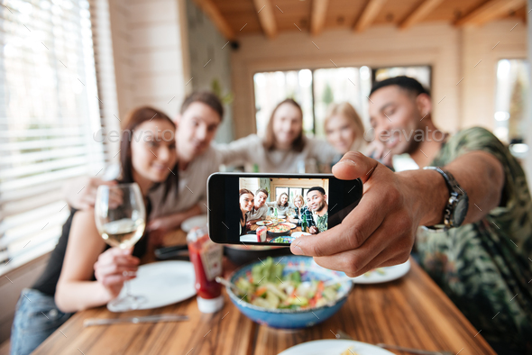 Group of friends having dinner and taking selfie with smartphone - Stock Photo - Images
