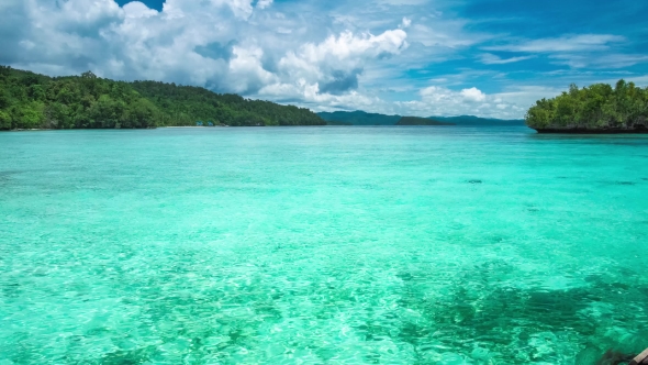 Beautiful Blue Lagoon with Pure Clear Water and Rainy Clouds in Background, Gam Island, West Papua alt