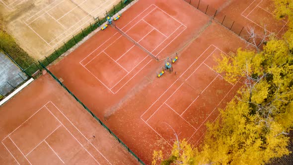 Aerial tennis courts in city park, yellow autumn