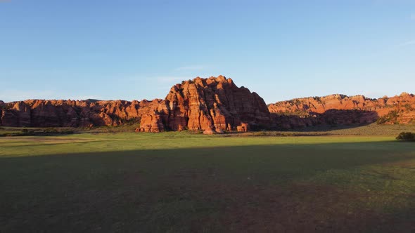 Beautiful drone shot flying over a desert in Utah with mountain rocks alt