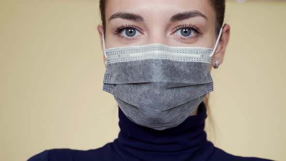 Portrait of Young Woman in Protective Medical Mask Looking at Camera, Isolated alt