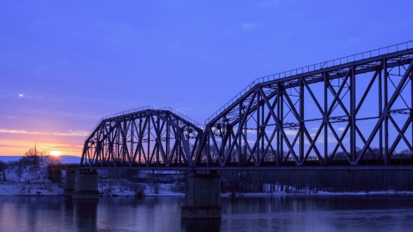 Railway Bridge Over the River at Dawn with a Mountain Forest and Traffic Highway