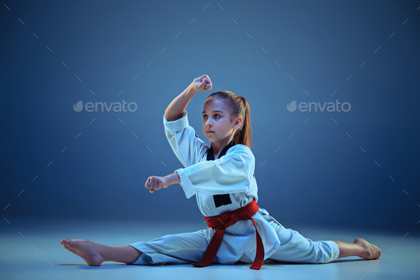 Young girl training karate on blue background Stock Photo by master1305