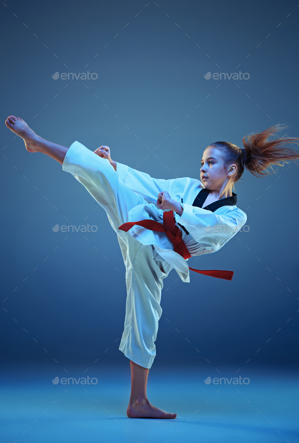 Young girl training karate on blue background Stock Photo by master1305