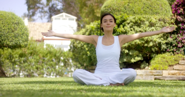 Gorgeous Young Woman in White Sitting on Lawn alt