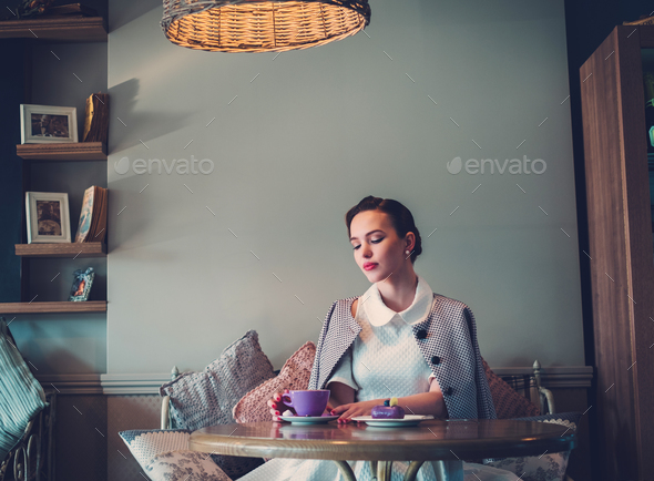 Elegant young lady alone in a cafe