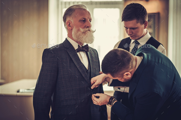 Tailor and his protege measuring client for custom made garment - Stock Photo - Images